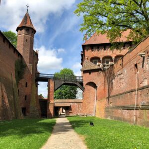 Explore the historic beauty of a medieval Gothic castle courtyard in Poland, perfect for travel inspiration.