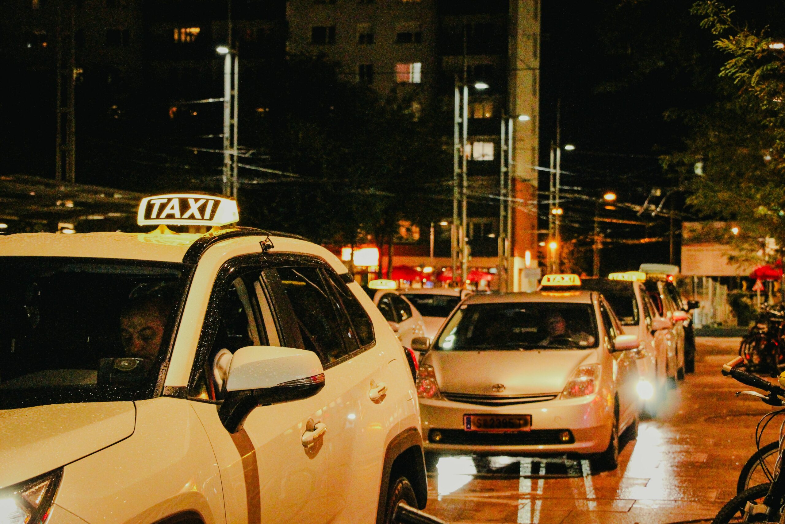 Taxis lined up under streetlights in Salzburg, Austria, captured at night.