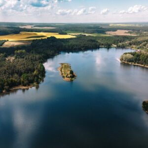 Stunning aerial shot of a lake with surrounding forest and fields in the Grodno Region of Belarus.